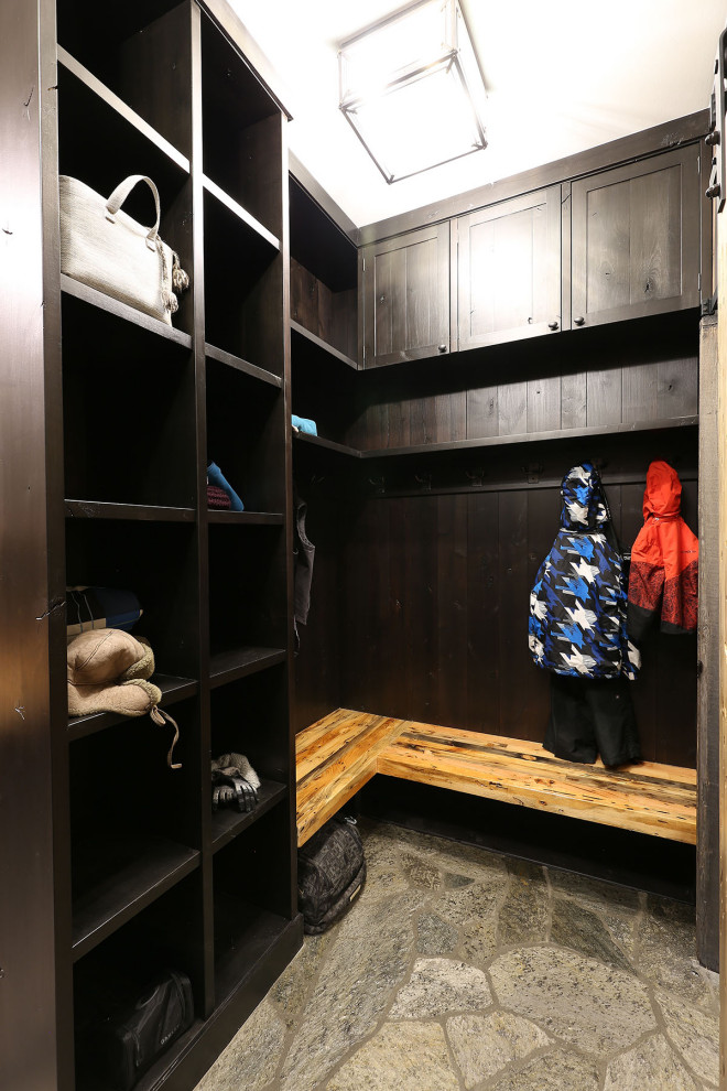 Example of a large mountain style gray floor mudroom design with a dark wood front door
