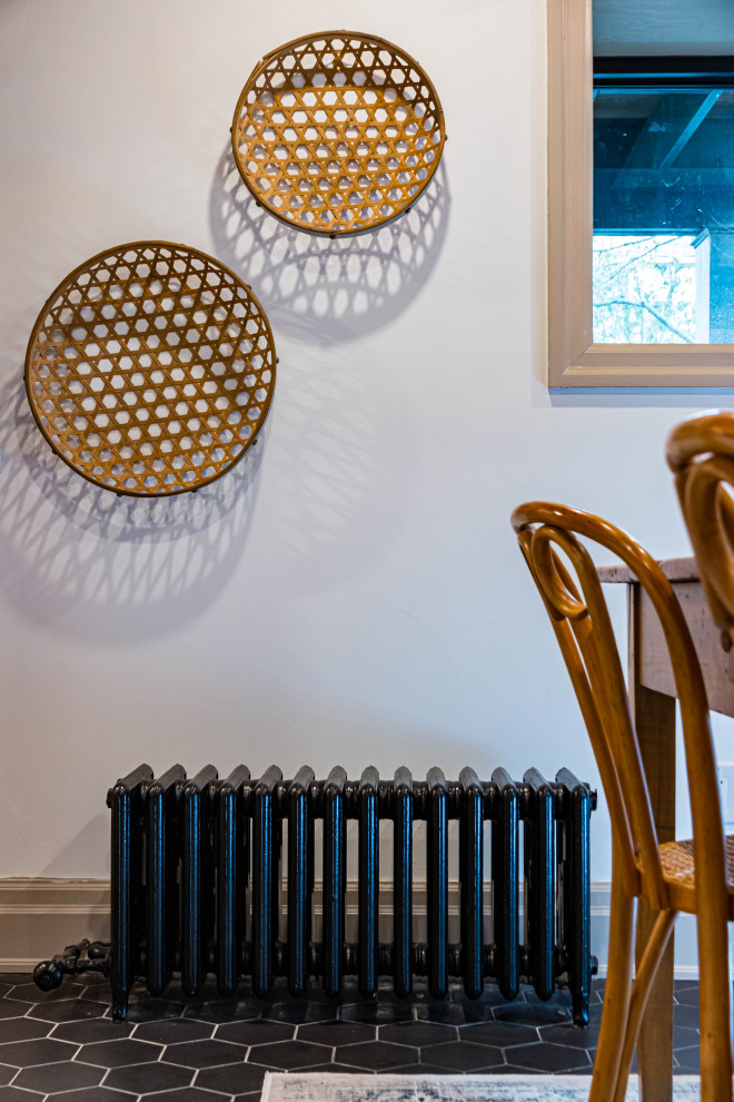 Eat-in kitchen - mid-sized rustic u-shaped ceramic tile, black floor and exposed beam eat-in kitchen idea in Toronto with a farmhouse sink, flat-panel cabinets, white cabinets, quartz countertops, white backsplash, subway tile backsplash, stainless steel appliances, an island and gray countertops
