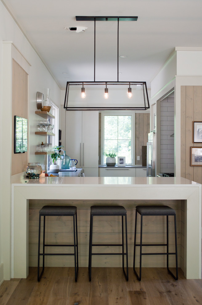 Inspiration for a mid-sized contemporary u-shaped separate kitchen in Other with open cabinets, light wood cabinets, light hardwood floors, a peninsula, quartz benchtops, white splashback, subway tile splashback, stainless steel appliances and brown floor.