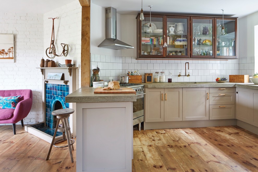 Design ideas for an eclectic eat-in kitchen in Devon with a farmhouse sink, shaker cabinets, brown cabinets, concrete benchtops, subway tile splashback and light hardwood floors.
