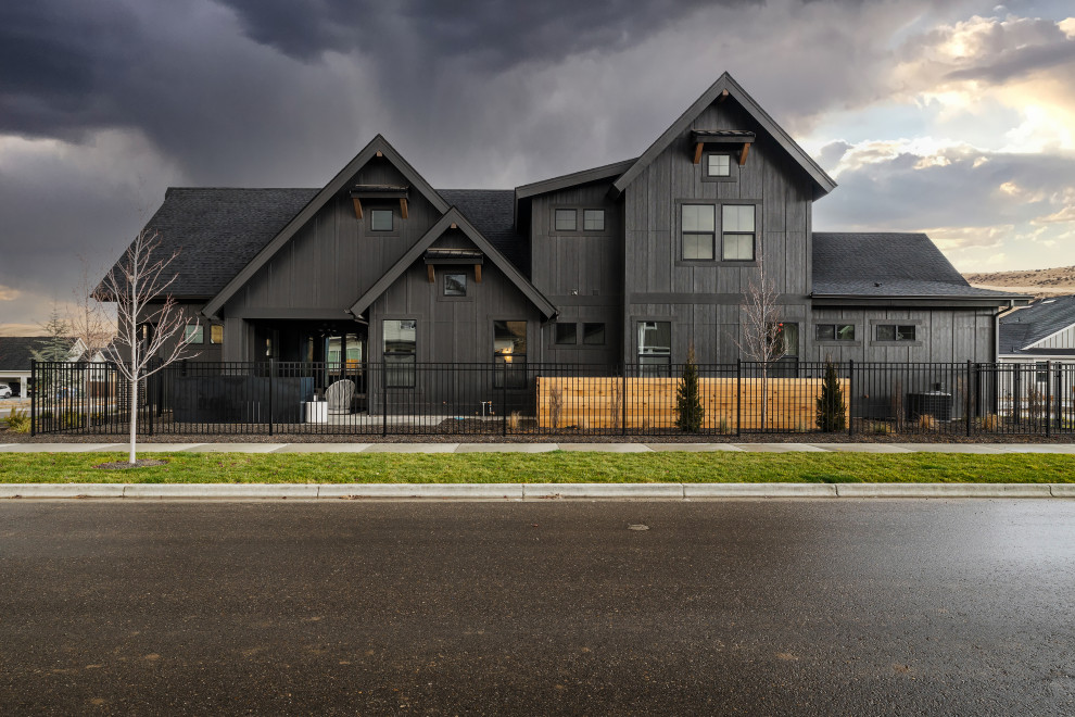 Mittelgroßes, Zweistöckiges Nordisches Einfamilienhaus mit Backsteinfassade, schwarzer Fassadenfarbe, Satteldach, Schindeldach, schwarzem Dach und Verschalung in Boise