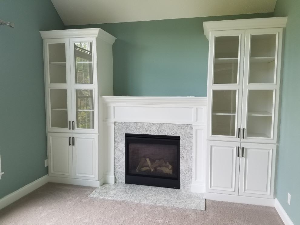Inspiration for a small enclosed family room in Cleveland with blue walls, carpet, a standard fireplace, a stone fireplace surround, no tv and grey floor.