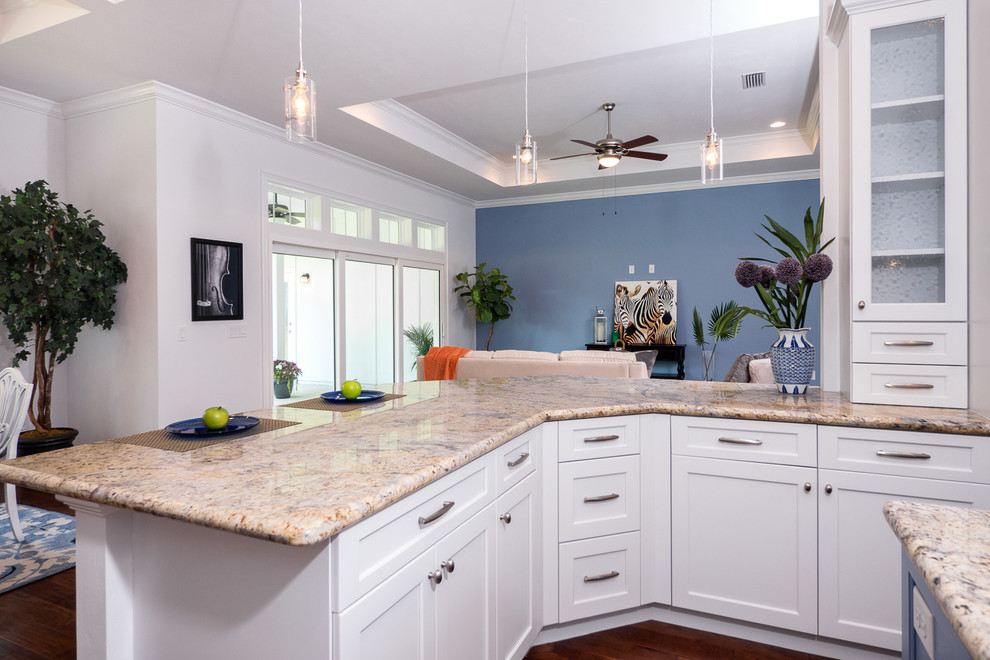 This is an example of a contemporary kitchen in Jacksonville with shaker cabinets, white cabinets, granite benchtops, beige splashback, cement tile splashback, stainless steel appliances, dark hardwood floors and multiple islands.