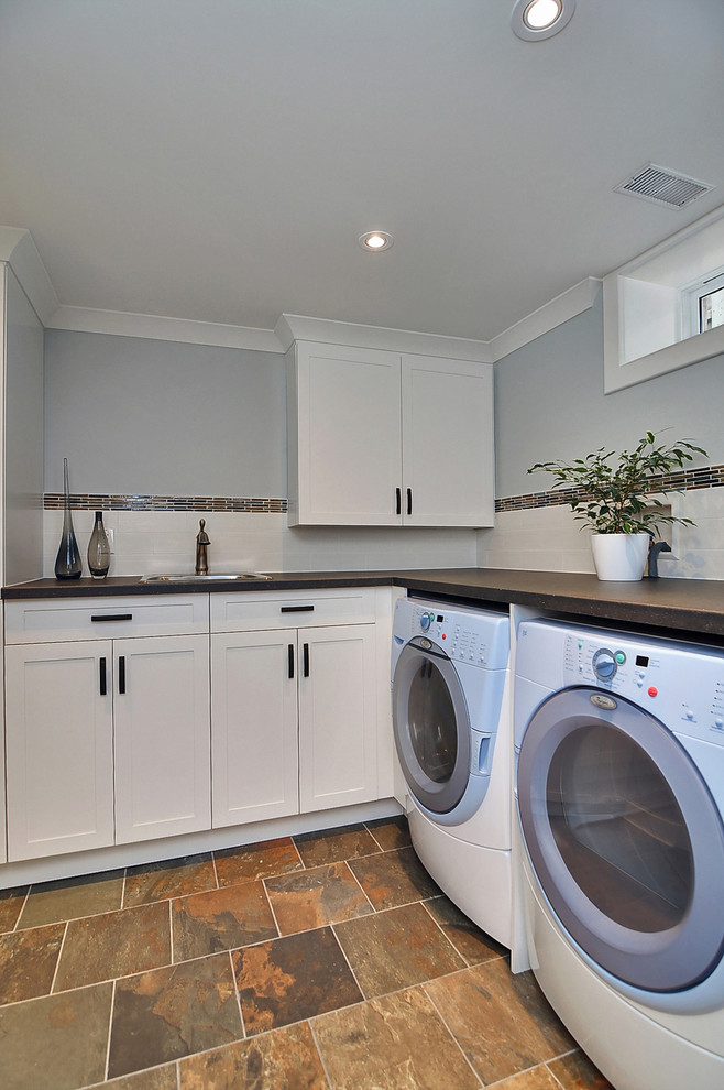 Small arts and crafts laundry room in Ottawa with blue walls and slate floors.