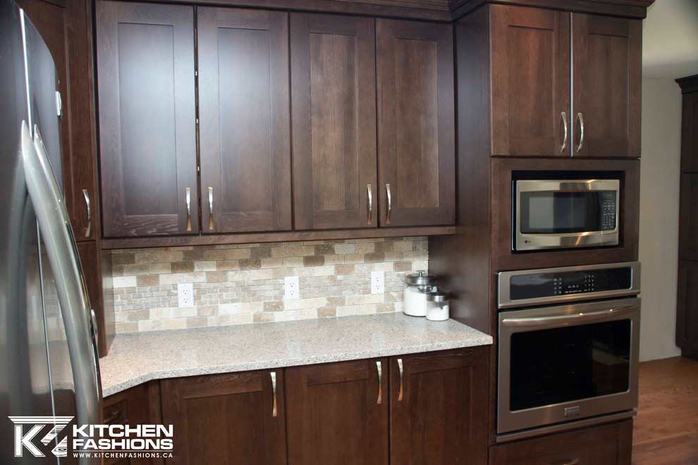 Example of a large transitional u-shaped medium tone wood floor open concept kitchen design with a farmhouse sink, shaker cabinets, dark wood cabinets, quartz countertops, brown backsplash, stone tile backsplash, stainless steel appliances and an island