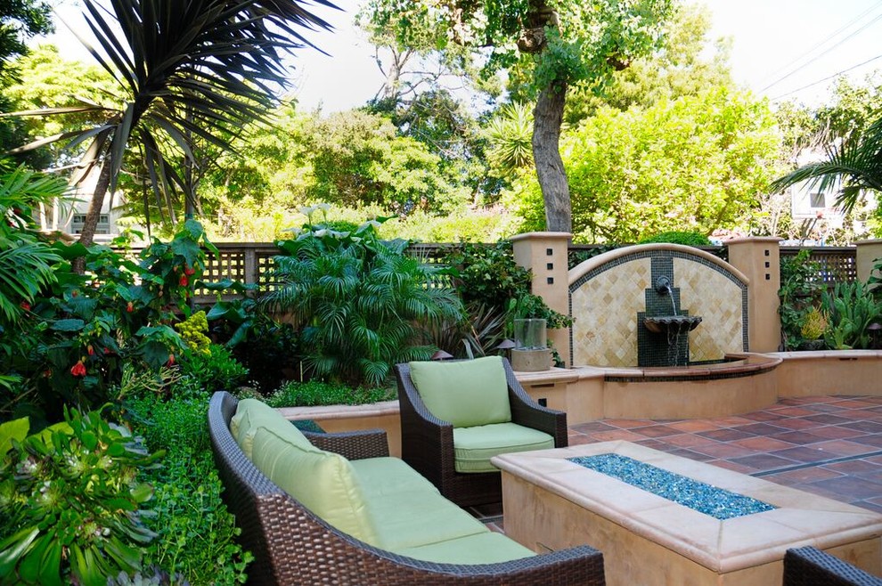 This is an example of a small mediterranean backyard partial sun garden in San Francisco with a water feature.