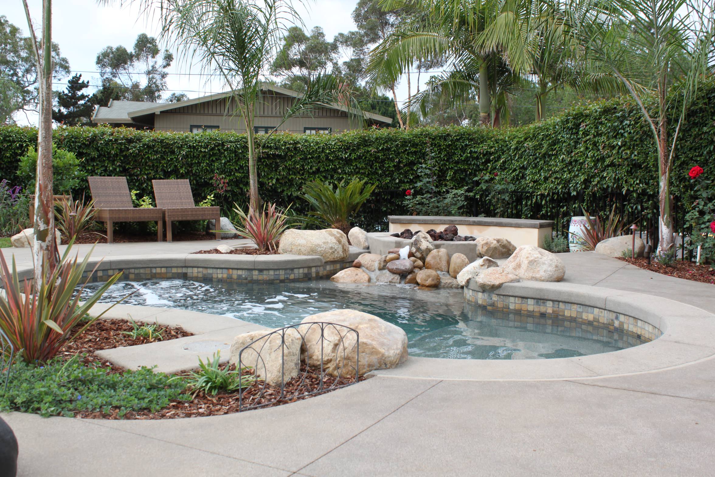A Spool, Spa and Pool Combination with Fire Pit Above