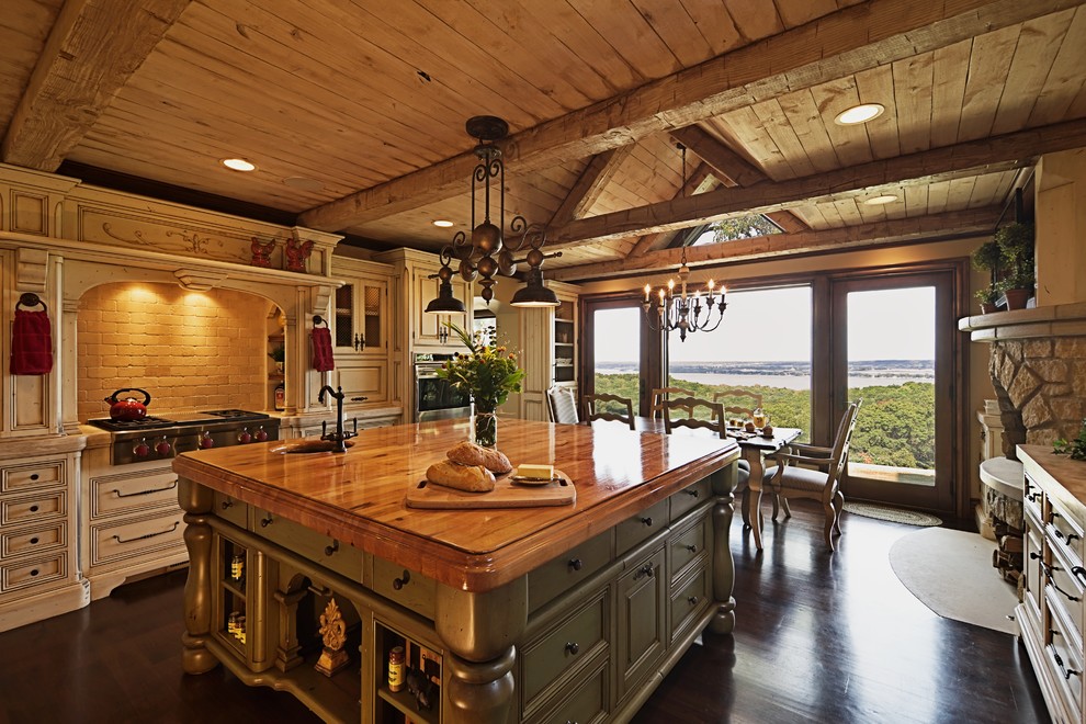Eat-in kitchen - rustic u-shaped eat-in kitchen idea in Chicago with a farmhouse sink, beaded inset cabinets, white cabinets, limestone countertops, beige backsplash, subway tile backsplash and paneled appliances