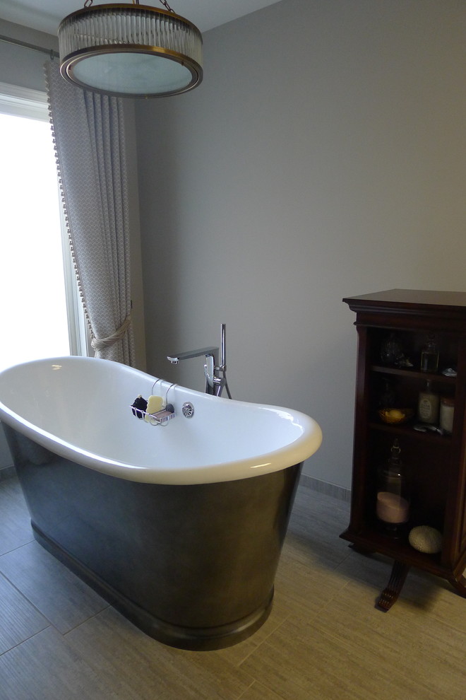 Inspiration for a large transitional master gray tile and porcelain tile porcelain tile freestanding bathtub remodel in Indianapolis with a drop-in sink, furniture-like cabinets, dark wood cabinets, solid surface countertops, a one-piece toilet and gray walls