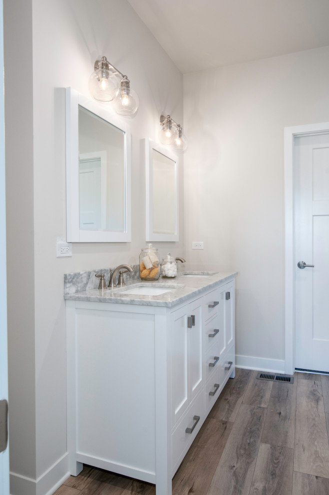 Small transitional master vinyl floor and brown floor bathroom photo in Chicago with shaker cabinets, white cabinets, an undermount sink, marble countertops and gray countertops