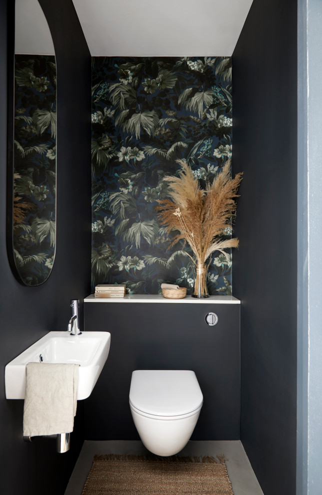 Cette image montre un WC suspendu design avec un mur multicolore, un lavabo suspendu, un sol gris et du papier peint.