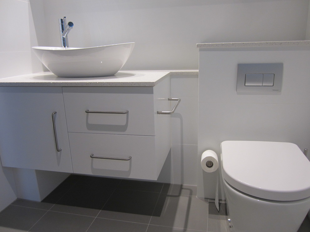 Photo of a modern master bathroom in Sydney with a vessel sink, white cabinets, engineered quartz benchtops, a drop-in tub, a shower/bathtub combo, white tile, white walls and ceramic floors.