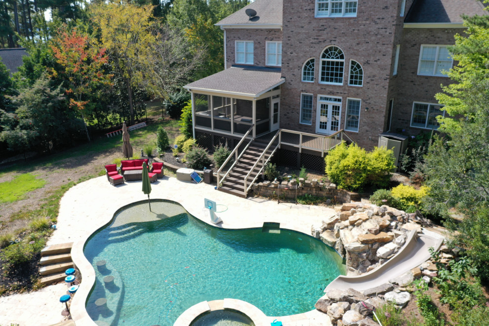 Example of a mid-sized backyard deck design in Charlotte with no cover