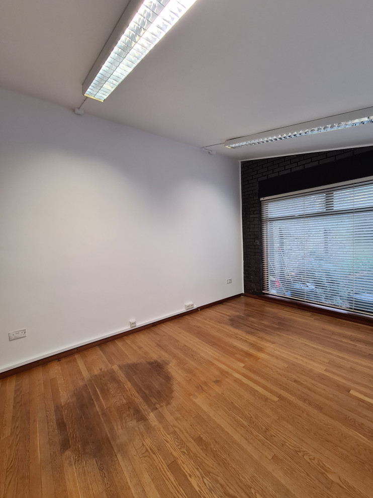 Diseño de sala de manualidades minimalista grande con paredes blancas, suelo de madera oscura, suelo marrón y bandeja