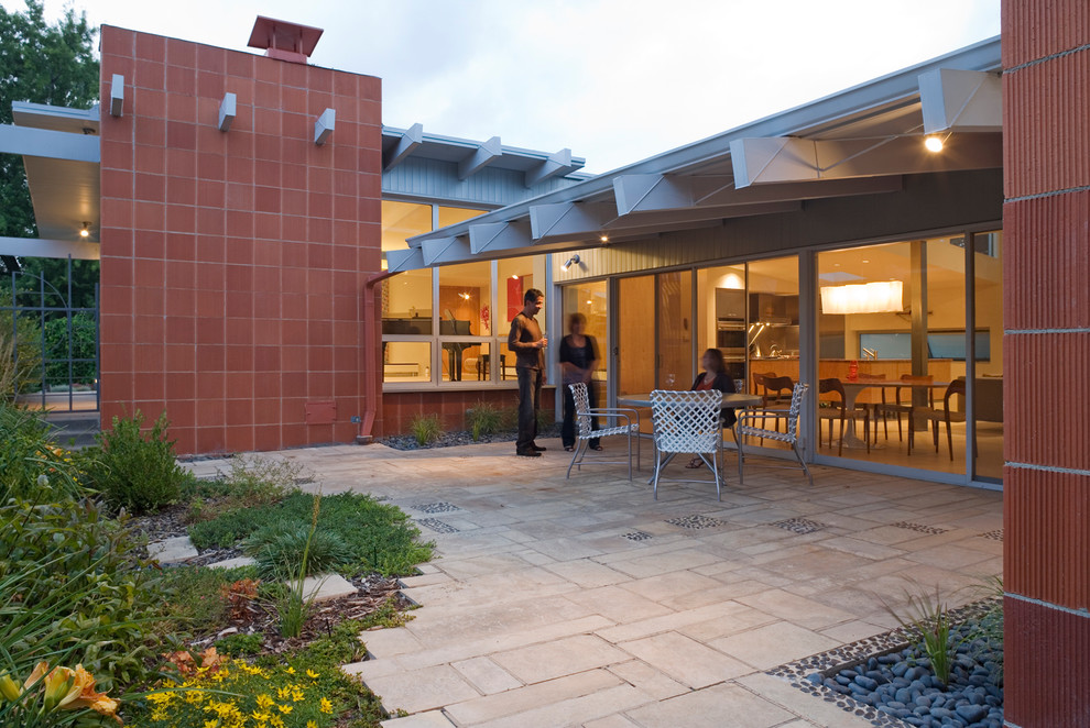 Photo of a contemporary patio in Denver with brick pavers.