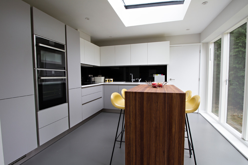 This is an example of a mid-sized modern eat-in kitchen in Surrey with concrete floors and grey floor.
