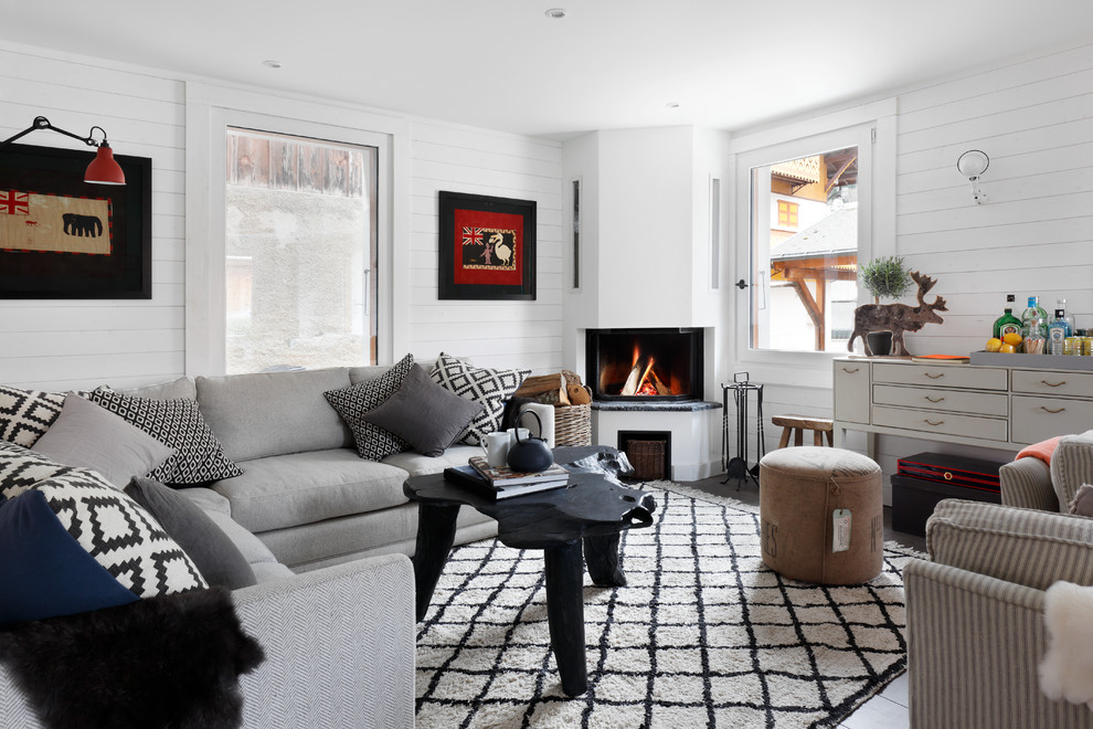 Photo of a mid-sized scandinavian open concept living room in Lyon with white walls, medium hardwood floors, a corner fireplace and no tv.