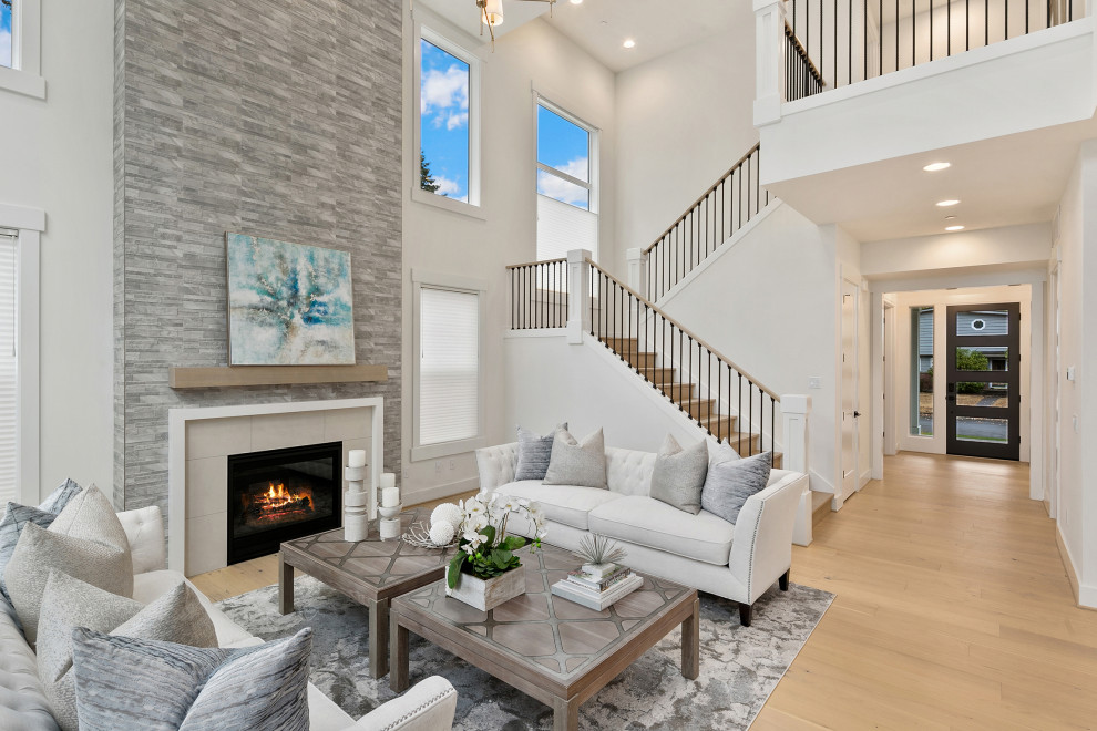 Inspiration for a large country open plan living room in Seattle with white walls, light hardwood flooring, a standard fireplace, a stone fireplace surround, no tv and brown floors.