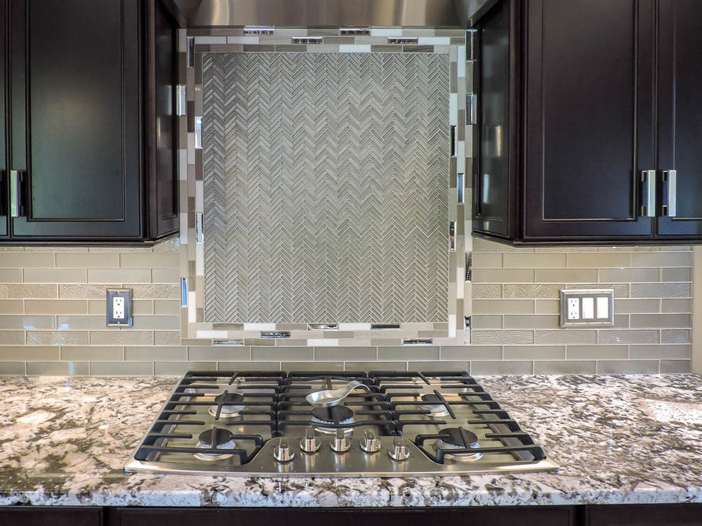 Example of a large transitional u-shaped porcelain tile and beige floor eat-in kitchen design in Bridgeport with an undermount sink, raised-panel cabinets, dark wood cabinets, granite countertops, green backsplash, glass tile backsplash, stainless steel appliances, an island and brown countertops