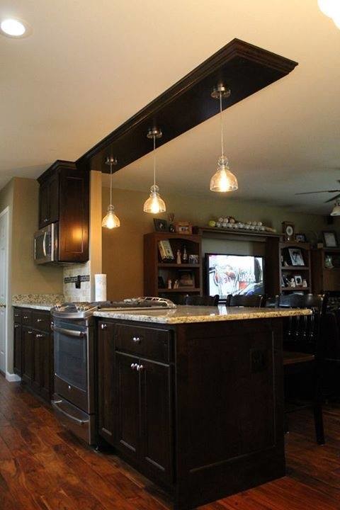 Example of a large classic u-shaped dark wood floor and brown floor enclosed kitchen design with shaker cabinets, dark wood cabinets, granite countertops, stainless steel appliances and a peninsula