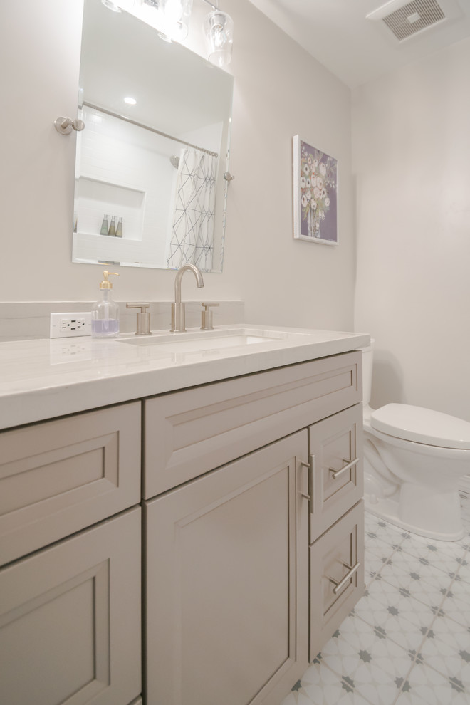 Mid-sized transitional kids bathroom in San Francisco with recessed-panel cabinets, white cabinets, a drop-in tub, a shower/bathtub combo, white tile, ceramic tile, beige walls, ceramic floors, an undermount sink, quartzite benchtops, a shower curtain and grey benchtops.