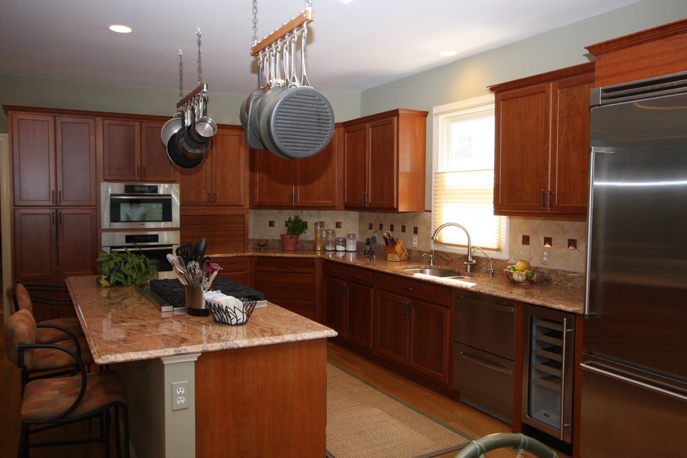 Inspiration for a mid-sized transitional u-shaped light wood floor eat-in kitchen remodel in DC Metro with a double-bowl sink, raised-panel cabinets, medium tone wood cabinets, granite countertops, beige backsplash, ceramic backsplash, stainless steel appliances and an island