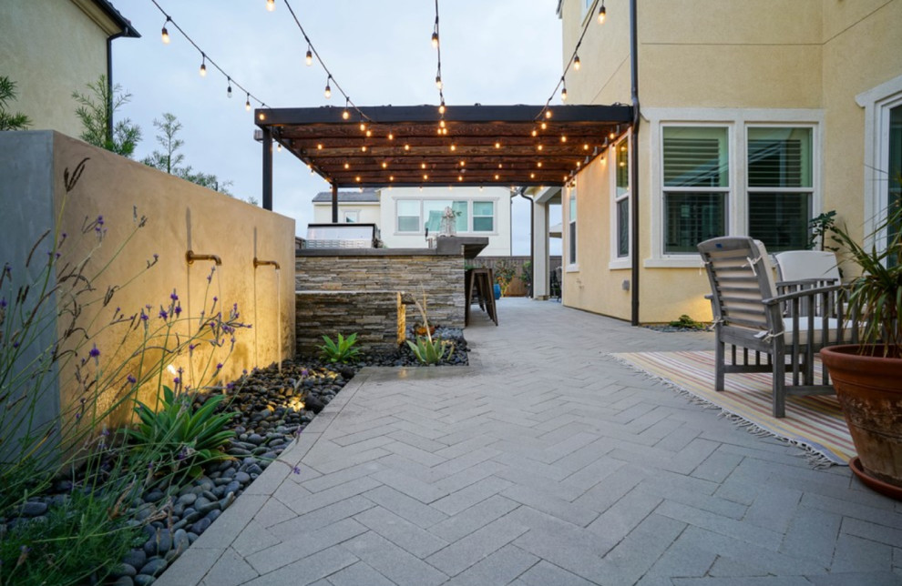 Inspiration for a small contemporary backyard partial sun xeriscape in San Diego with a water feature and concrete pavers.
