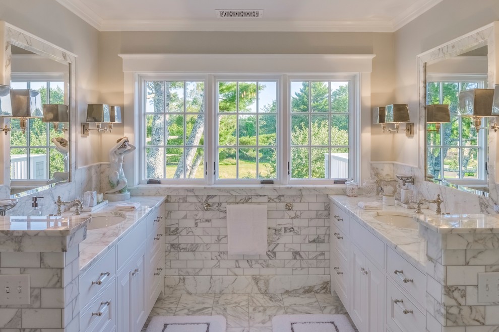 Photo of a large traditional master bathroom in Portland Maine with beaded inset cabinets, white cabinets, an alcove shower, a one-piece toilet, gray tile, marble, marble floors, an undermount sink, marble benchtops, white floor, a hinged shower door and beige walls.