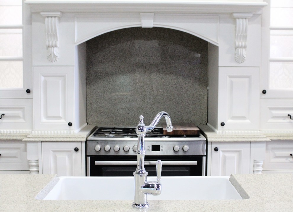 Design ideas for a large victorian single-wall open plan kitchen in Melbourne with an undermount sink, beige cabinets, white splashback and with island.