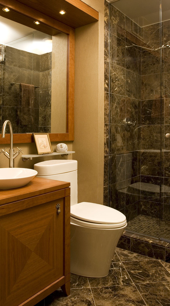 Mid-sized traditional 3/4 bathroom in Chicago with furniture-like cabinets, light wood cabinets, an alcove shower, a one-piece toilet, gray tile, ceramic tile, beige walls, ceramic floors, a vessel sink, wood benchtops, grey floor and a hinged shower door.
