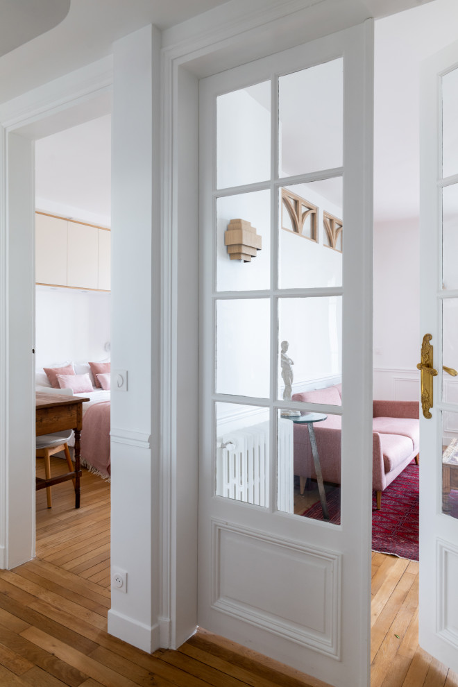 Idéer för att renovera en mellanstor skandinavisk foajé, med vita väggar och ljust trägolv