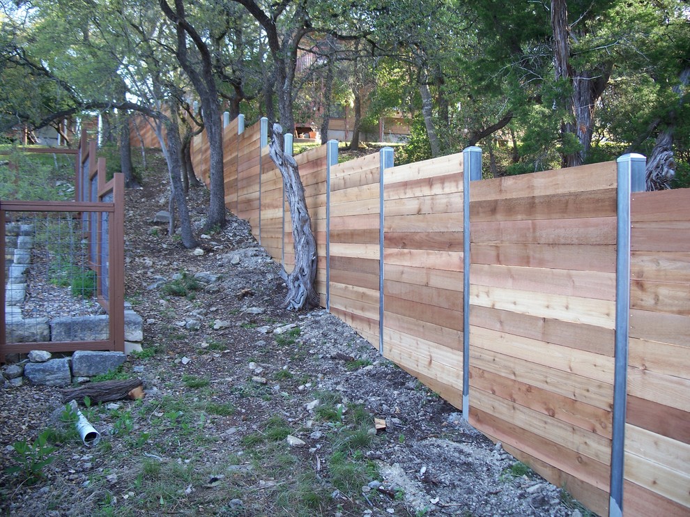 Design ideas for a mid-sized traditional backyard full sun garden for spring in Austin with a retaining wall.