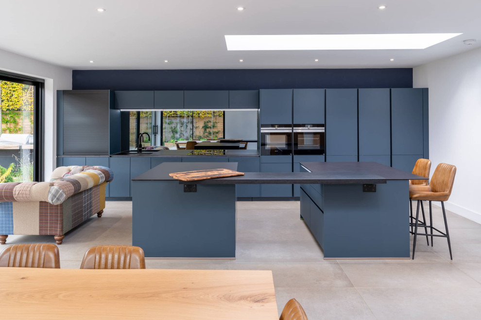 Idee per una grande cucina minimalista con ante lisce, ante blu, top in quarzite e top nero