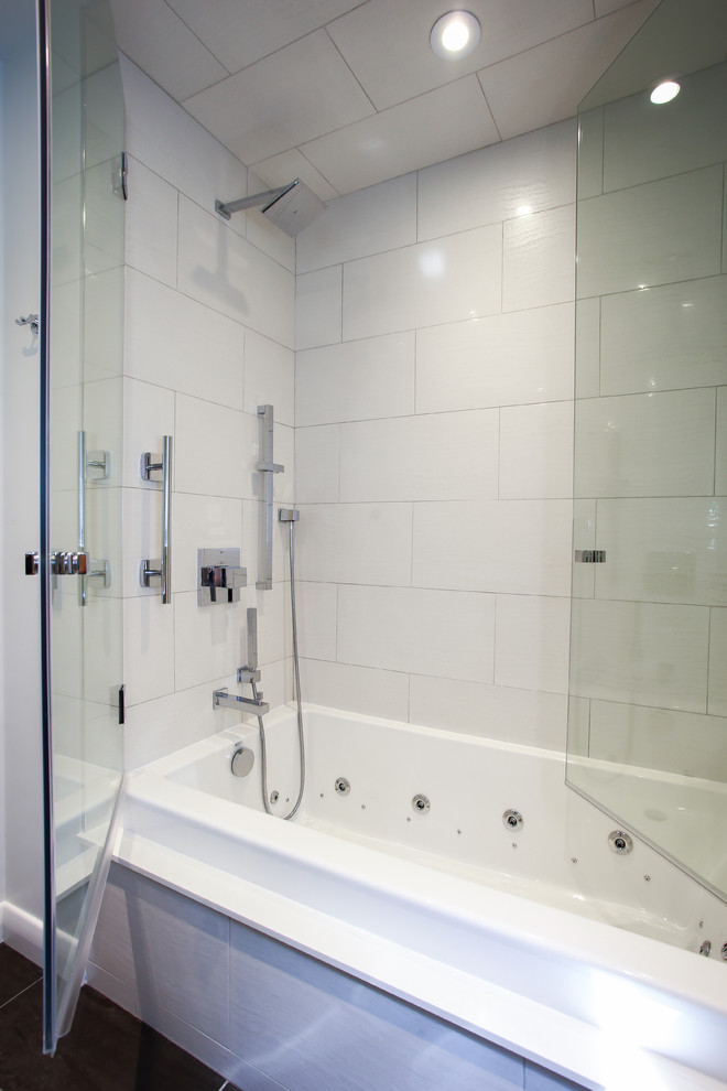Photo of a small contemporary kids bathroom in Toronto with an integrated sink, a shower/bathtub combo, a one-piece toilet, white tile, white walls, glass-front cabinets, glass benchtops, porcelain tile, porcelain floors and an alcove tub.