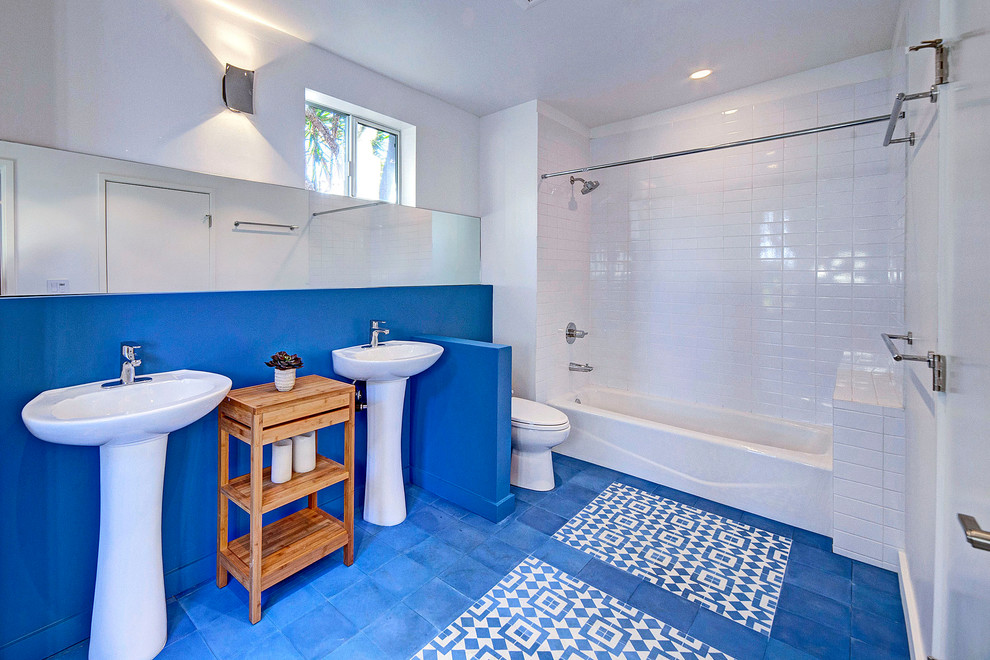 Design ideas for a large contemporary 3/4 bathroom in Other with an alcove tub, a shower/bathtub combo, a two-piece toilet, white tile, subway tile, white walls, vinyl floors, a pedestal sink, blue floor and a shower curtain.