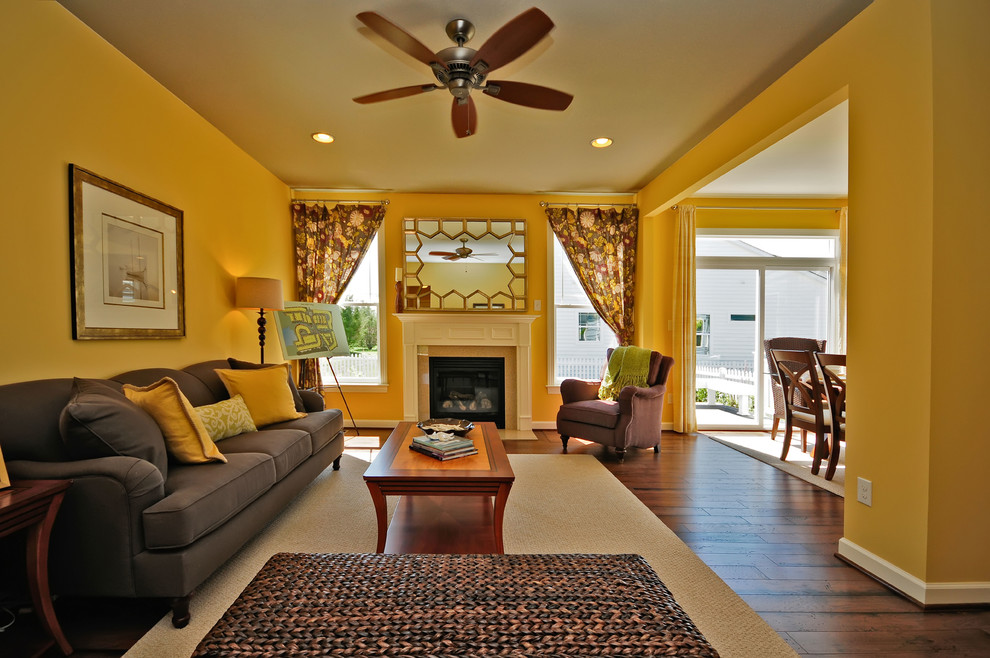 Beach style living room in Other with yellow walls, dark hardwood floors and a standard fireplace.