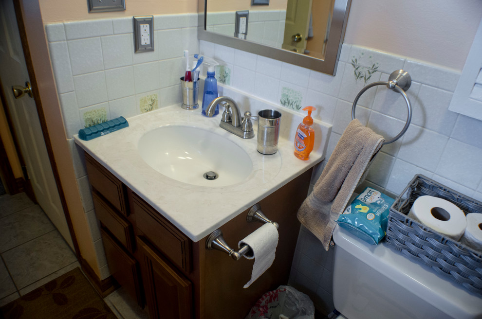 Inspiration for a transitional beige tile and porcelain tile porcelain tile alcove bathtub remodel in Chicago with raised-panel cabinets, medium tone wood cabinets, a two-piece toilet, blue walls, an integrated sink and marble countertops