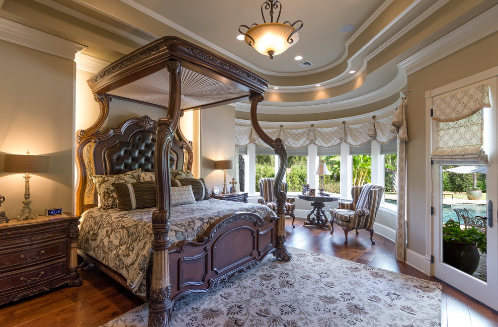 Photo of a large traditional master bedroom in New Orleans with dark hardwood floors and beige walls.
