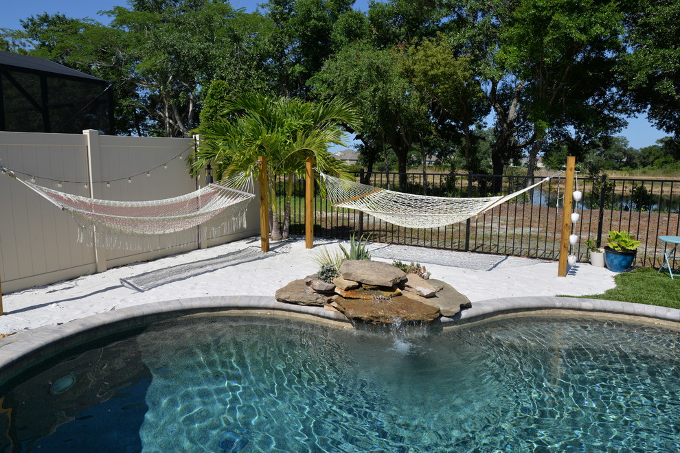 Photo of a mid-sized beach style backyard custom-shaped pool in Orlando with brick pavers.