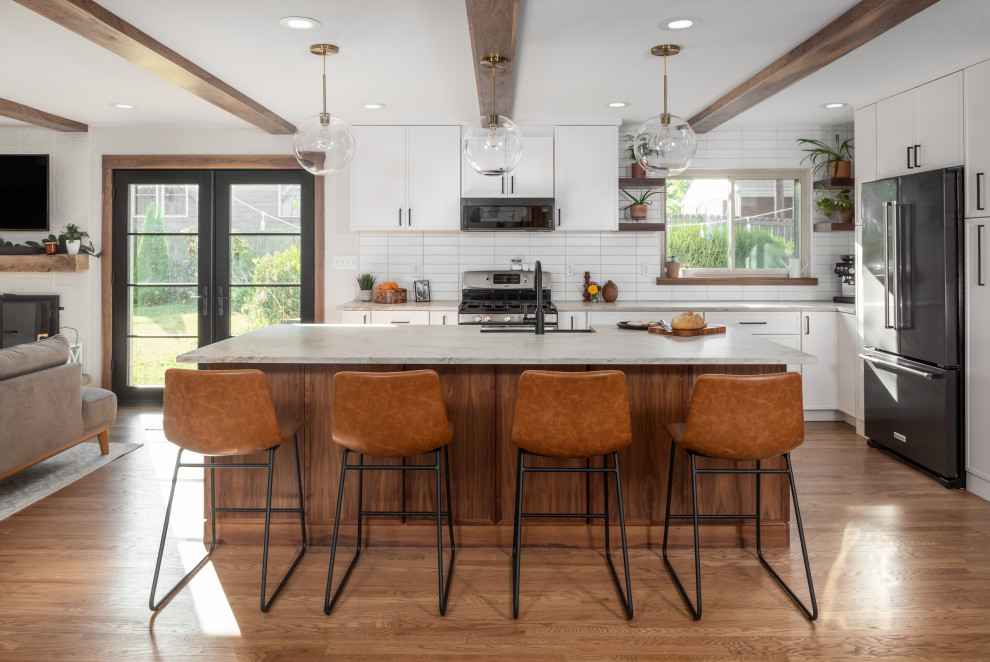 Inspiration for a mid-sized contemporary l-shaped open plan kitchen in St Louis with a farmhouse sink, flat-panel cabinets, brown cabinets, quartzite benchtops, white splashback, subway tile splashback, stainless steel appliances, medium hardwood floors, with island, brown floor, multi-coloured benchtop and exposed beam.