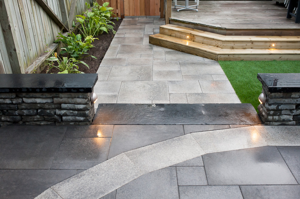 This is an example of a mid-sized modern backyard patio in Toronto with a container garden, tile and no cover.