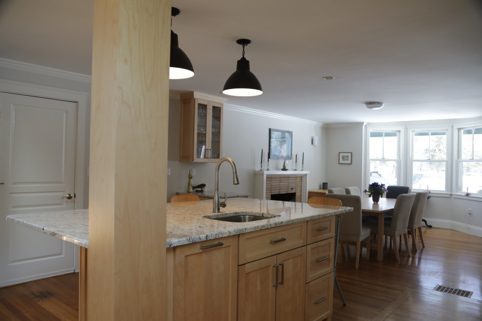 Inspiration for a large traditional l-shaped eat-in kitchen in Boston with an undermount sink, recessed-panel cabinets, light wood cabinets, granite benchtops, white splashback, ceramic splashback, stainless steel appliances, medium hardwood floors, with island and multi-coloured benchtop.