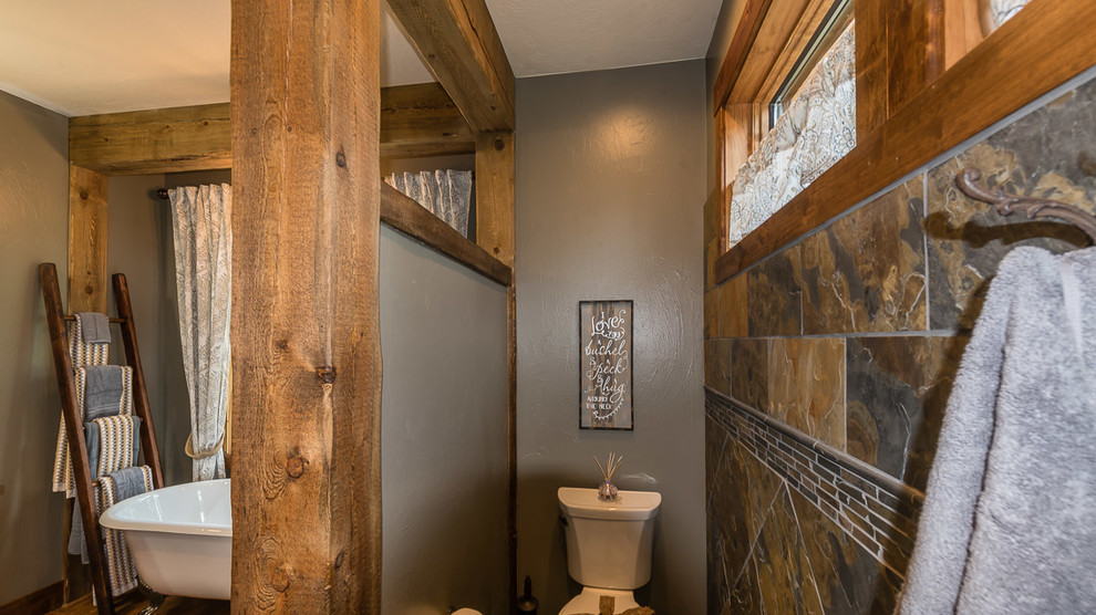 Claw-foot bathtub - rustic master claw-foot bathtub idea with a two-piece toilet and brown walls
