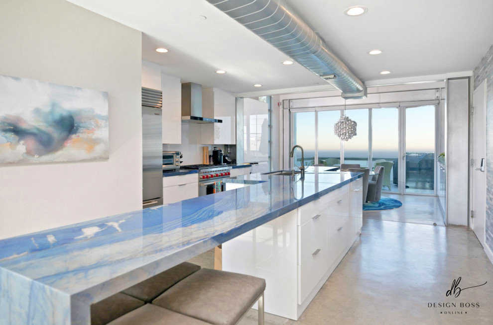 Photo of a small contemporary eat-in kitchen in San Diego with white cabinets, quartzite benchtops, grey splashback, stainless steel appliances, concrete floors, with island, grey floor and blue benchtop.