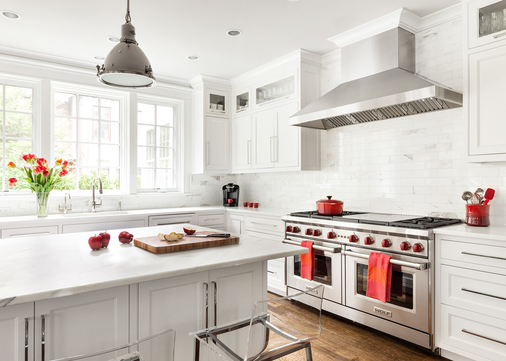 Mid-sized transitional u-shaped kitchen in New York with recessed-panel cabinets, white cabinets, white splashback, stone tile splashback, stainless steel appliances, dark hardwood floors and with island.