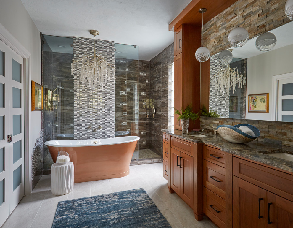 This is an example of a transitional master bathroom in Houston with shaker cabinets, medium wood cabinets, a freestanding tub, an alcove shower, multi-coloured tile, grey walls, an undermount sink, grey floor, a hinged shower door and multi-coloured benchtops.