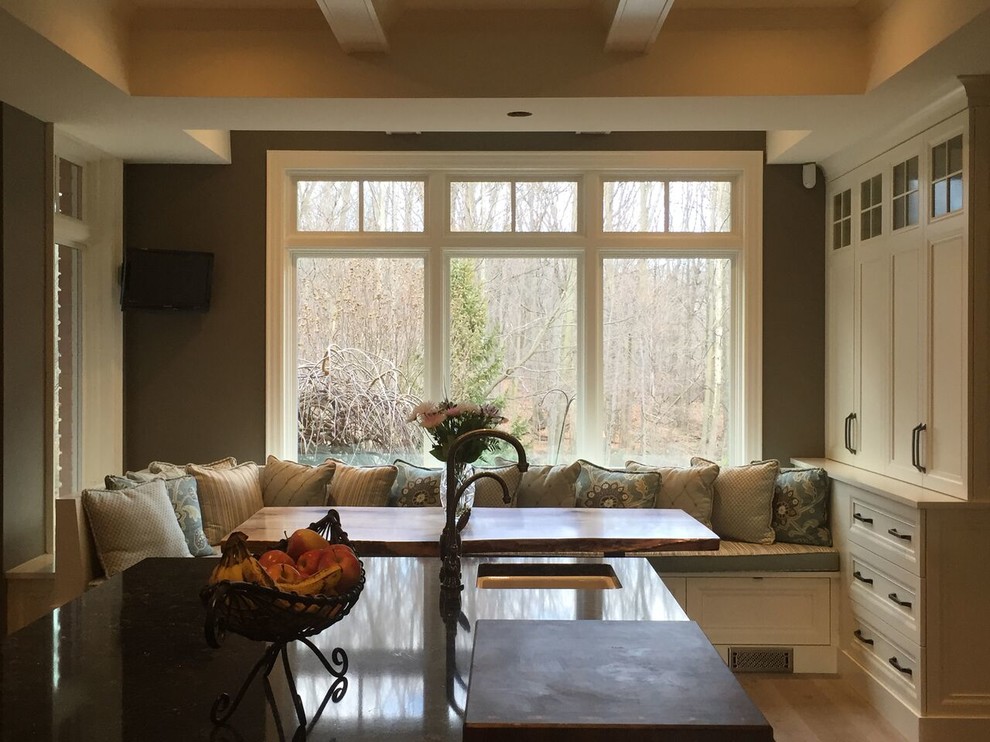 Example of a mid-sized transitional light wood floor and brown floor kitchen design in Toronto with an undermount sink, recessed-panel cabinets, white cabinets and an island