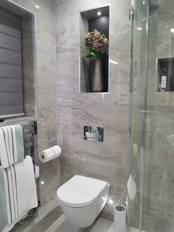 Photo of a medium sized contemporary ensuite bathroom in Other with flat-panel cabinets, dark wood cabinets, a corner shower, a wall mounted toilet, grey tiles, porcelain tiles, grey walls, porcelain flooring, a wall-mounted sink, grey floors and a hinged door.