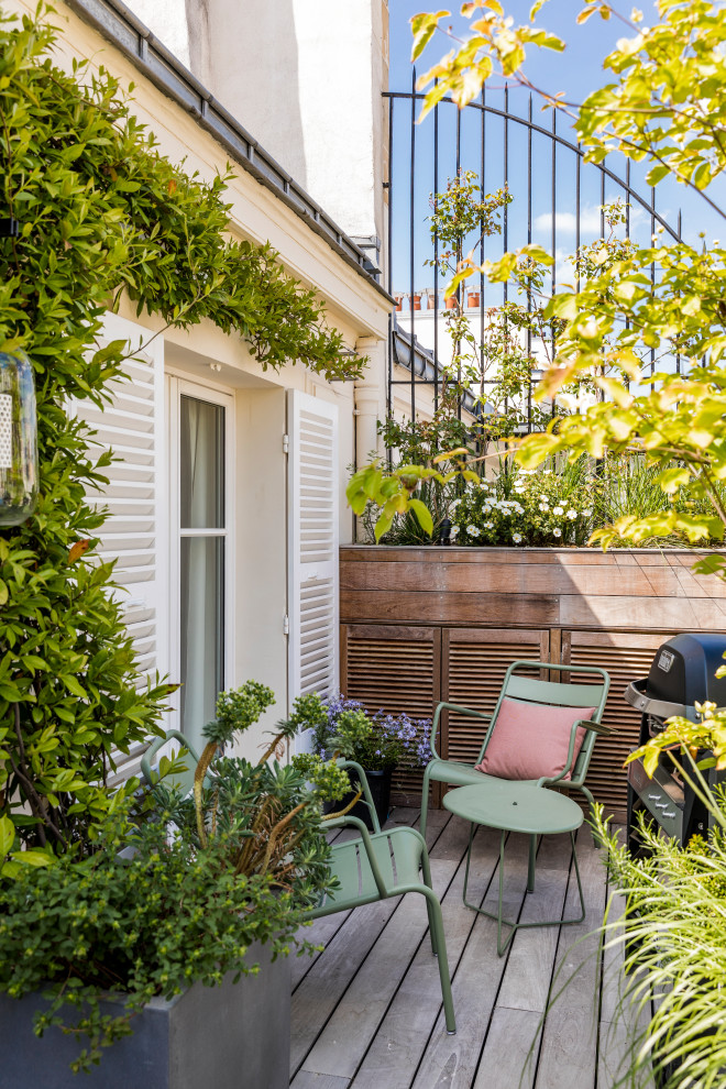 Imagen de terraza planta baja contemporánea de tamaño medio sin cubierta en patio lateral con jardín de macetas y barandilla de metal