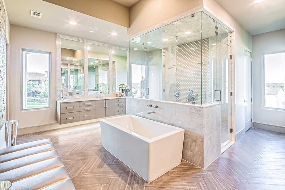 Design ideas for an expansive contemporary master bathroom in Dallas with flat-panel cabinets, grey cabinets, a freestanding tub, a double shower, a two-piece toilet, gray tile, marble, grey walls, ceramic floors, an undermount sink, engineered quartz benchtops, brown floor, a hinged shower door and white benchtops.